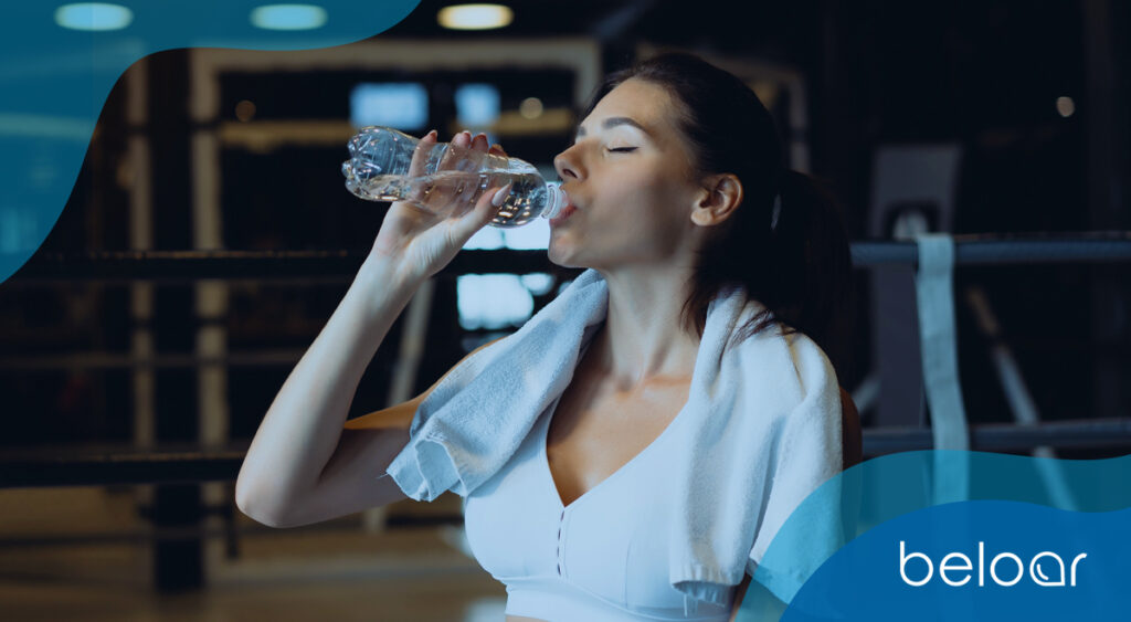 mulher jovem bebendo agua bebedouro industrial academia beloar